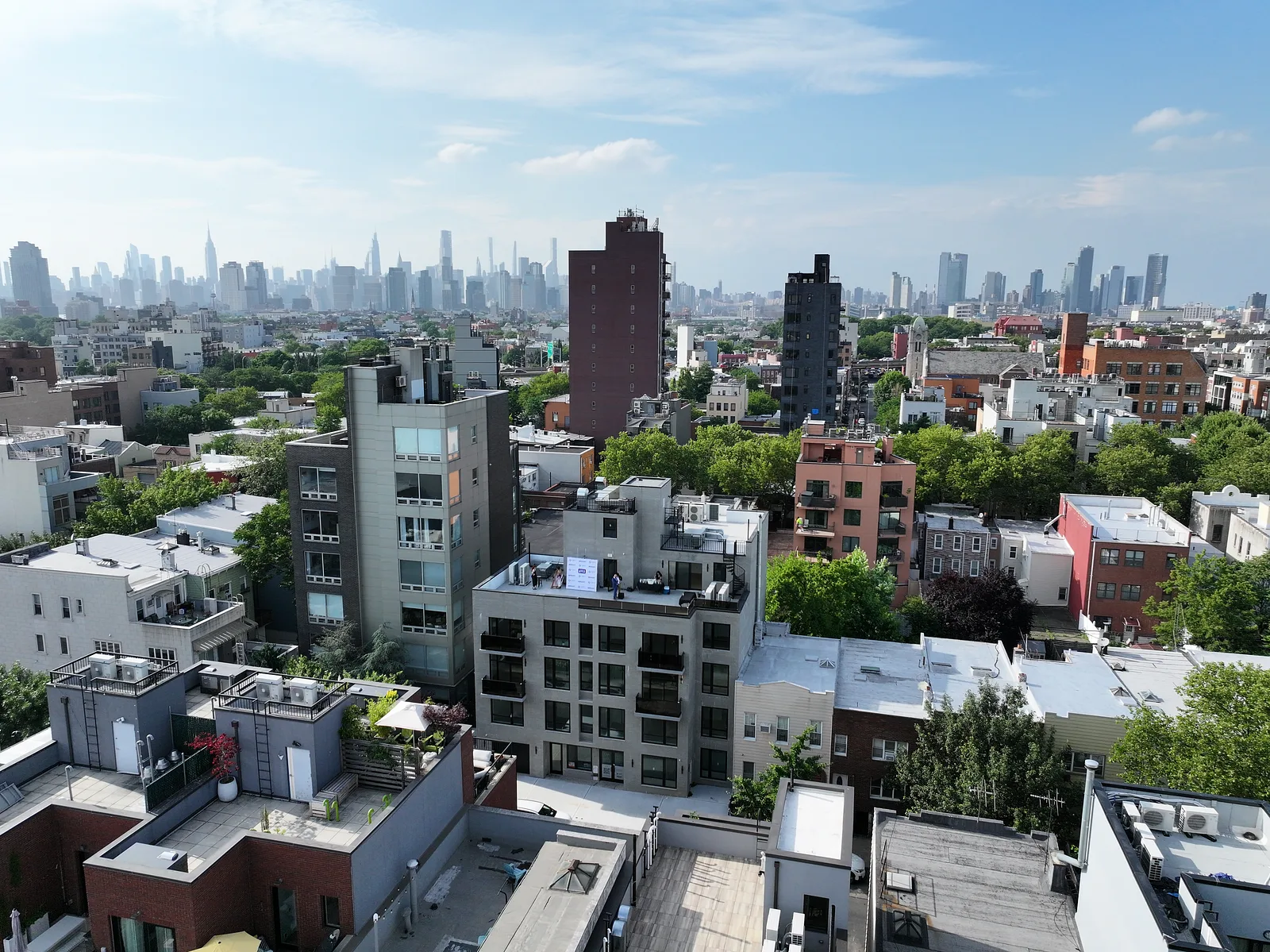 Brooklyn rooftops with the Manhattan skyline in the distance.