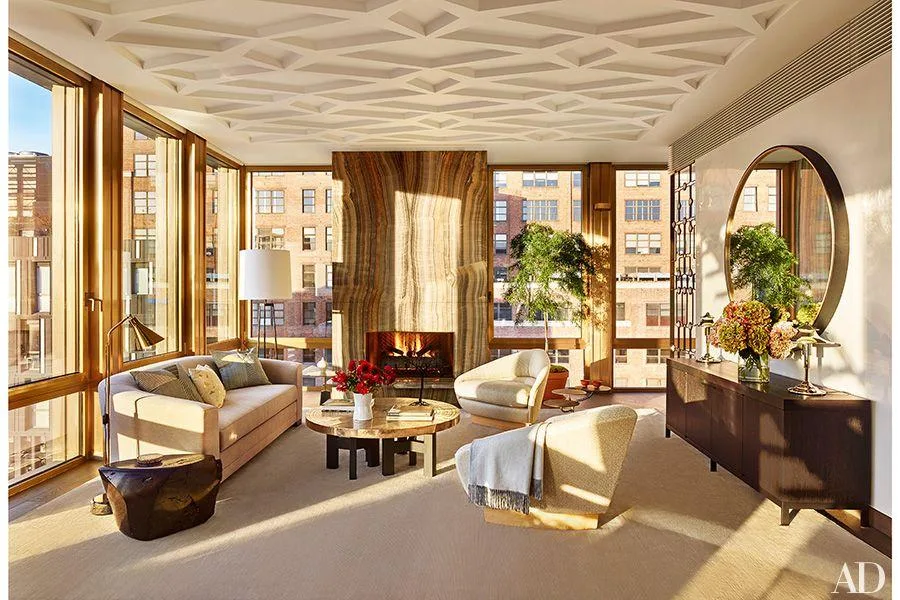 Manhattan living room with floor-to-ceiling windows, a stone fireplace, and views of neighboring buildings.